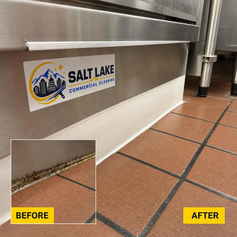 Freshly cleaned commercial kitchen floor edge beside a stainless prep table with grease buildup removed